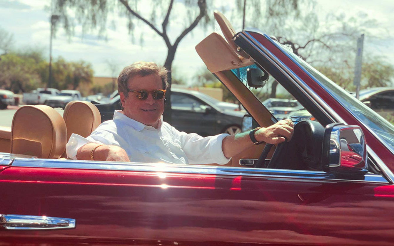 Tom Kurtz in red convertible on sunny day